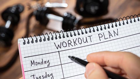 Person filling out a workout plan